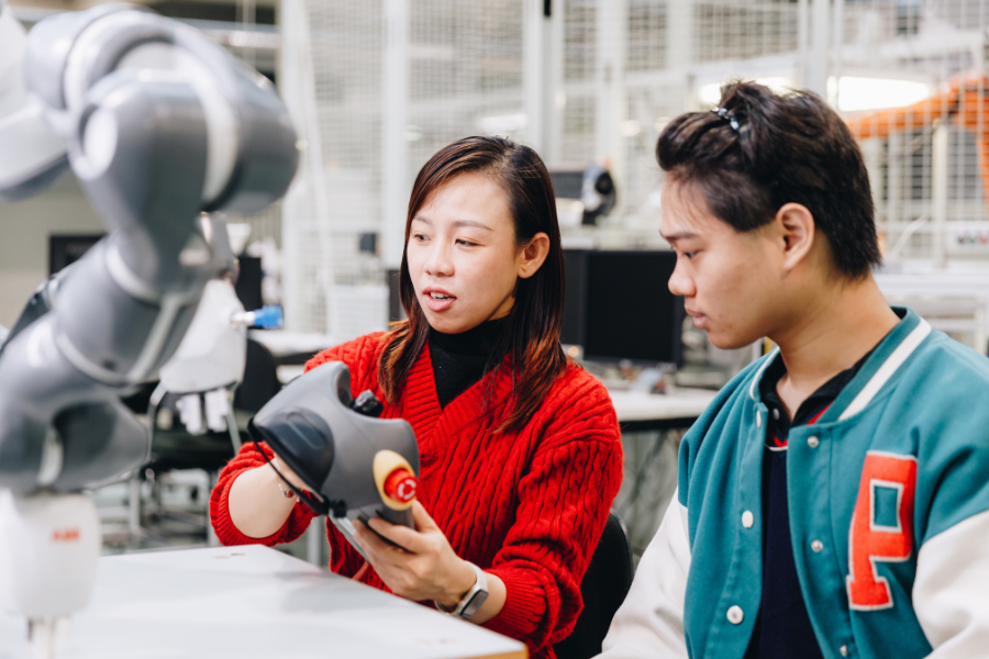 Two students at university laboratory, checking equipment