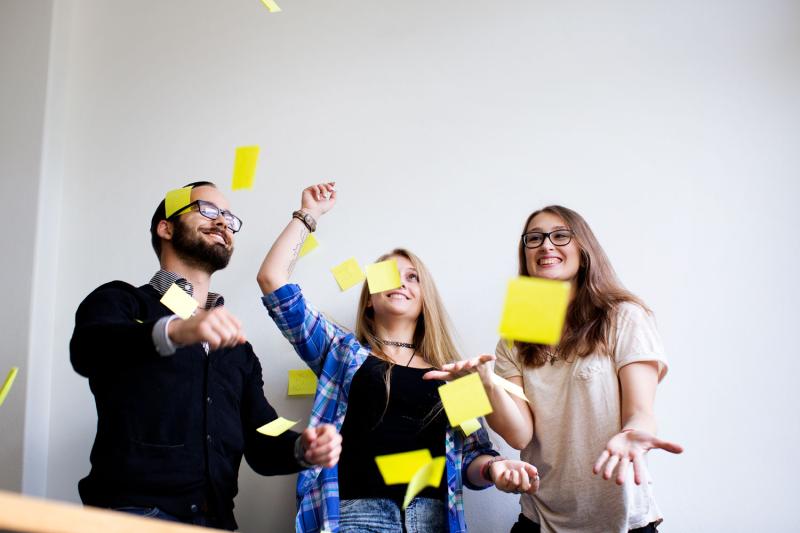 Picture of people throwing post-it notes in the air