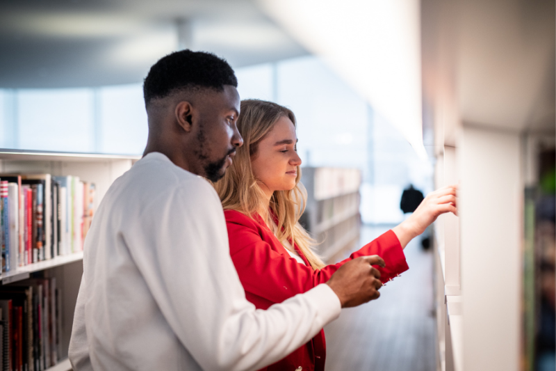 Students browsing library shelves