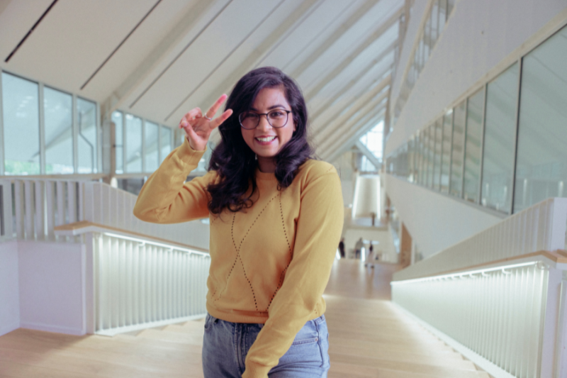 A merry female student at a modern university campus